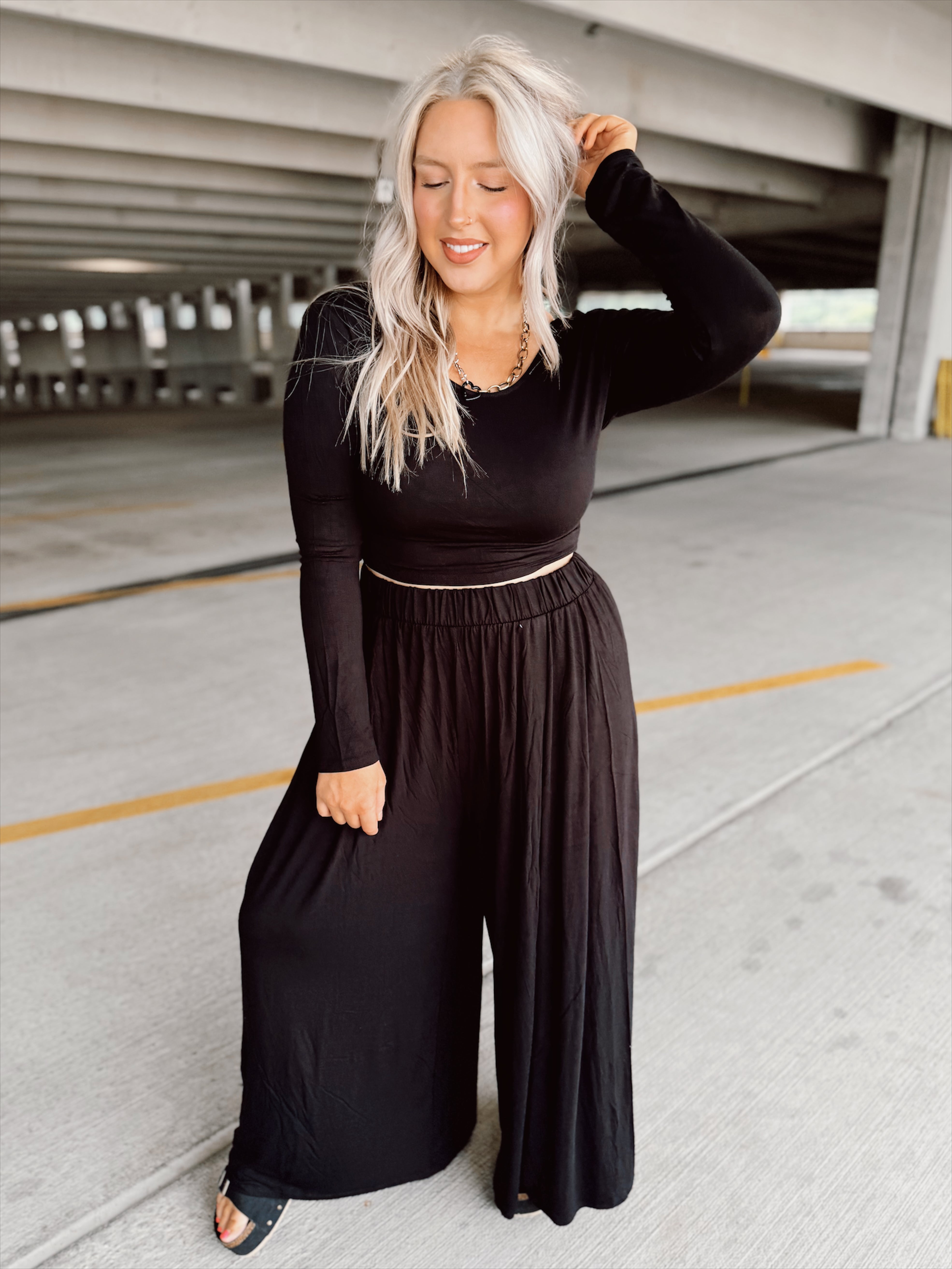 Woman wearing a black outfit in a parking garage.