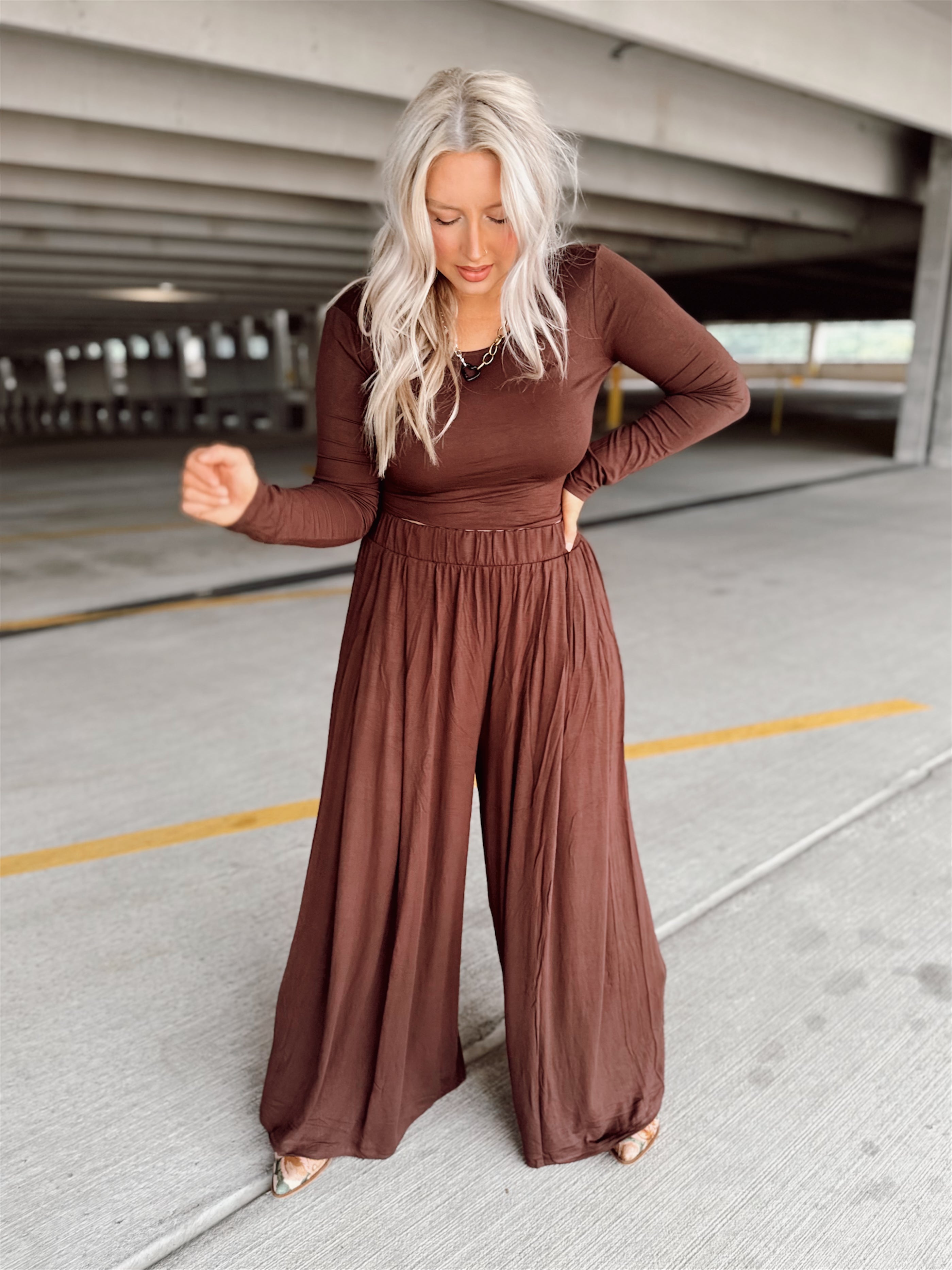 Person wearing a brown set standing in an parking garage.