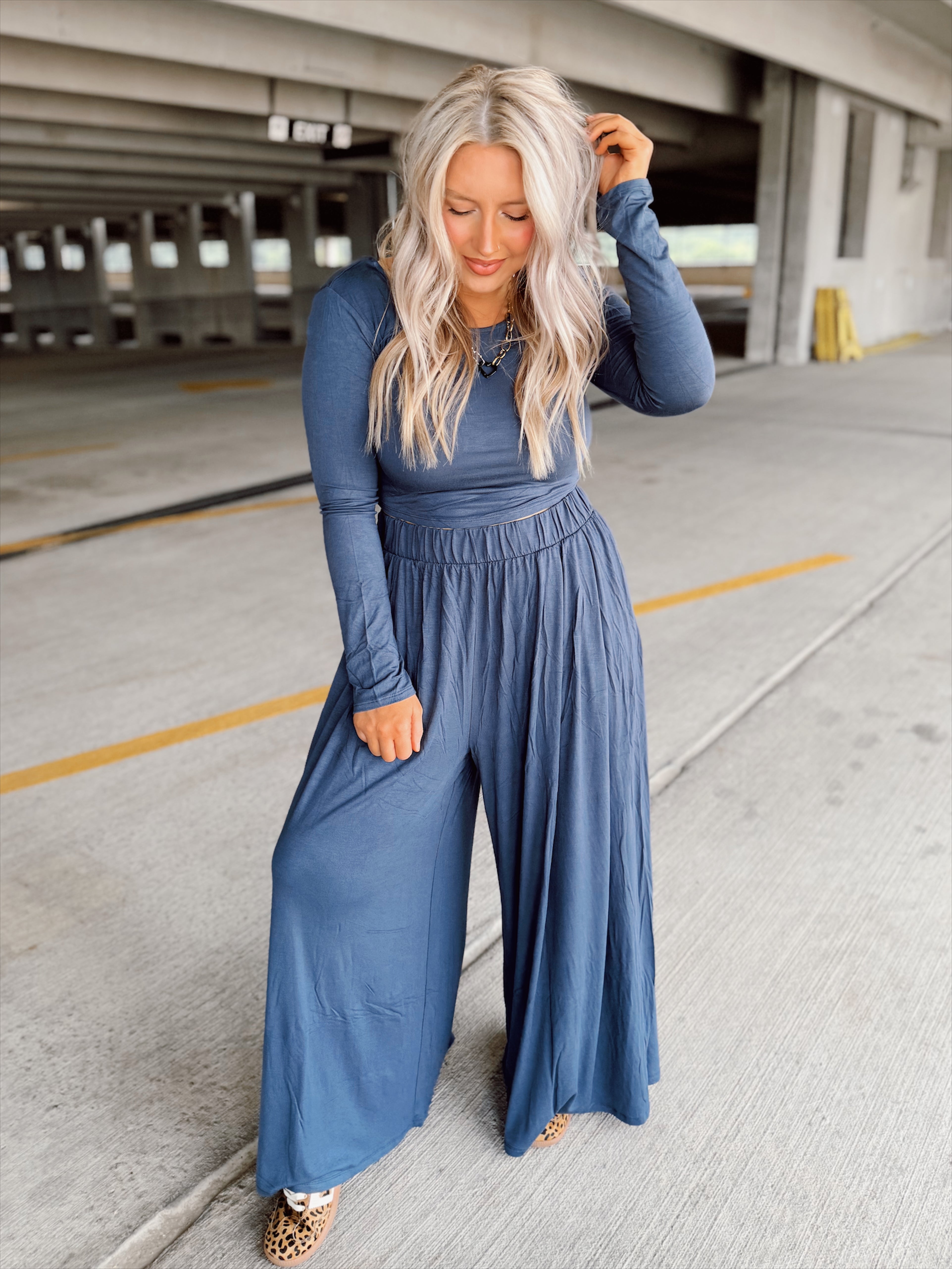 Person wearing a blue set standing in an parking garage.