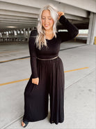 Woman wearing a black outfit in a parking garage.