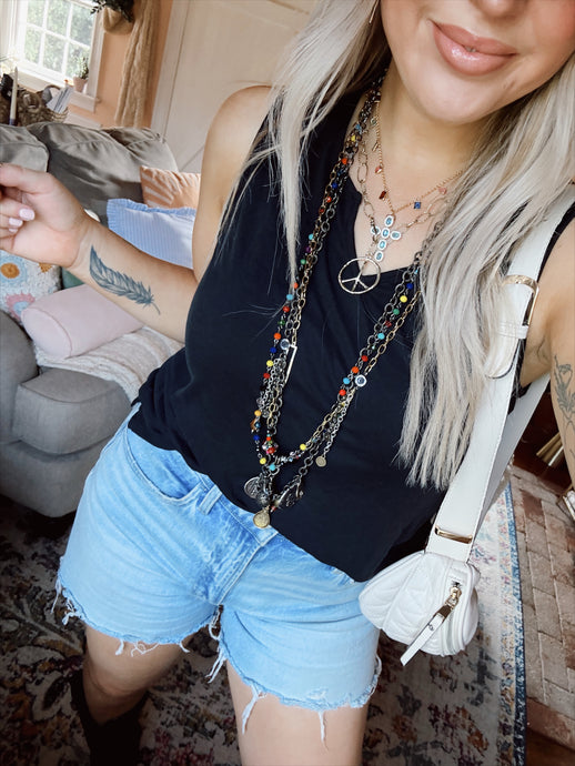 Woman standing with necklaces on in a living room. 