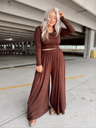 Person wearing a brown set standing in an parking garage.