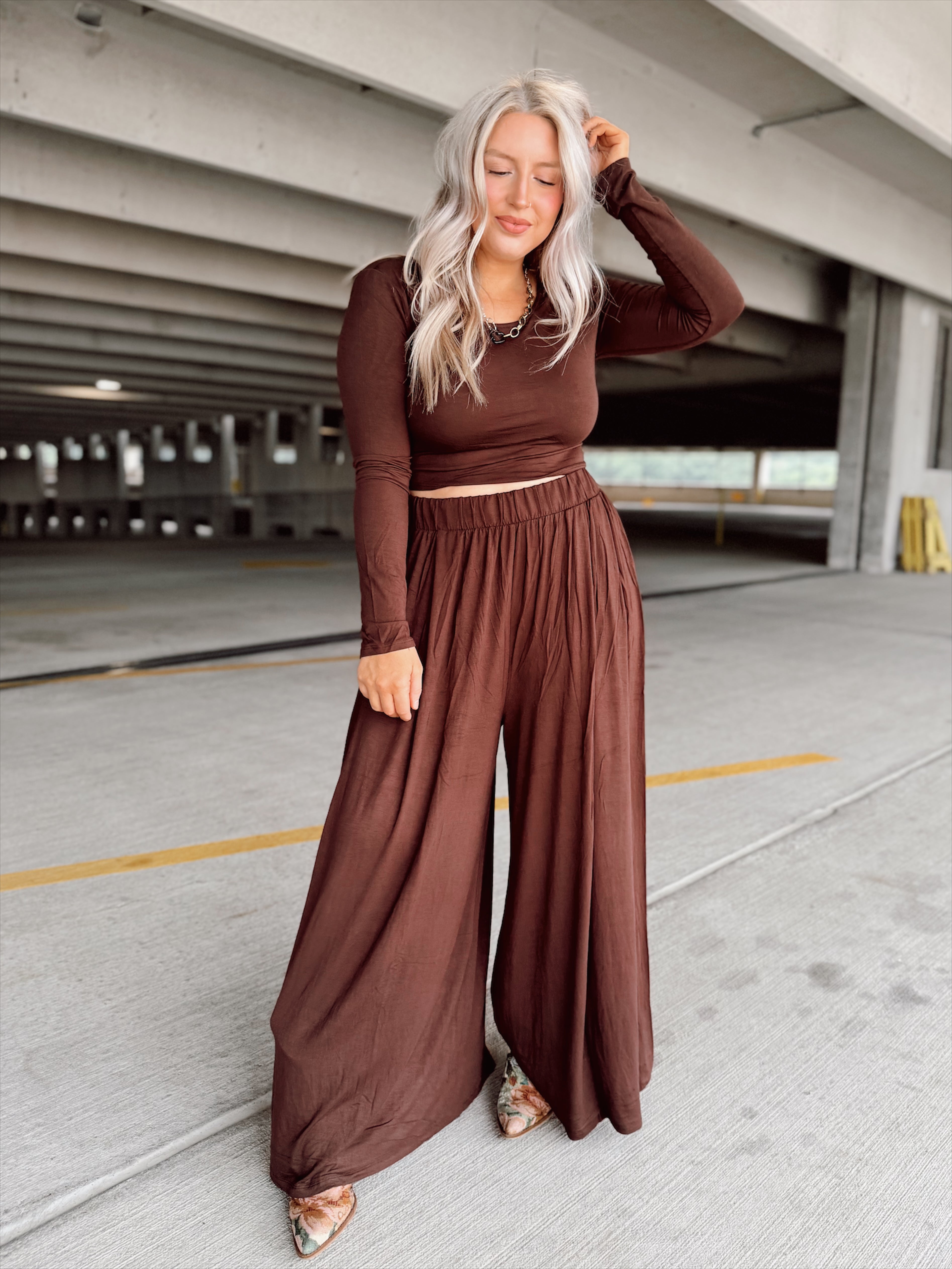 Person wearing a brown set standing in an parking garage.