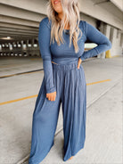 Person wearing a blue set standing in an parking garage.