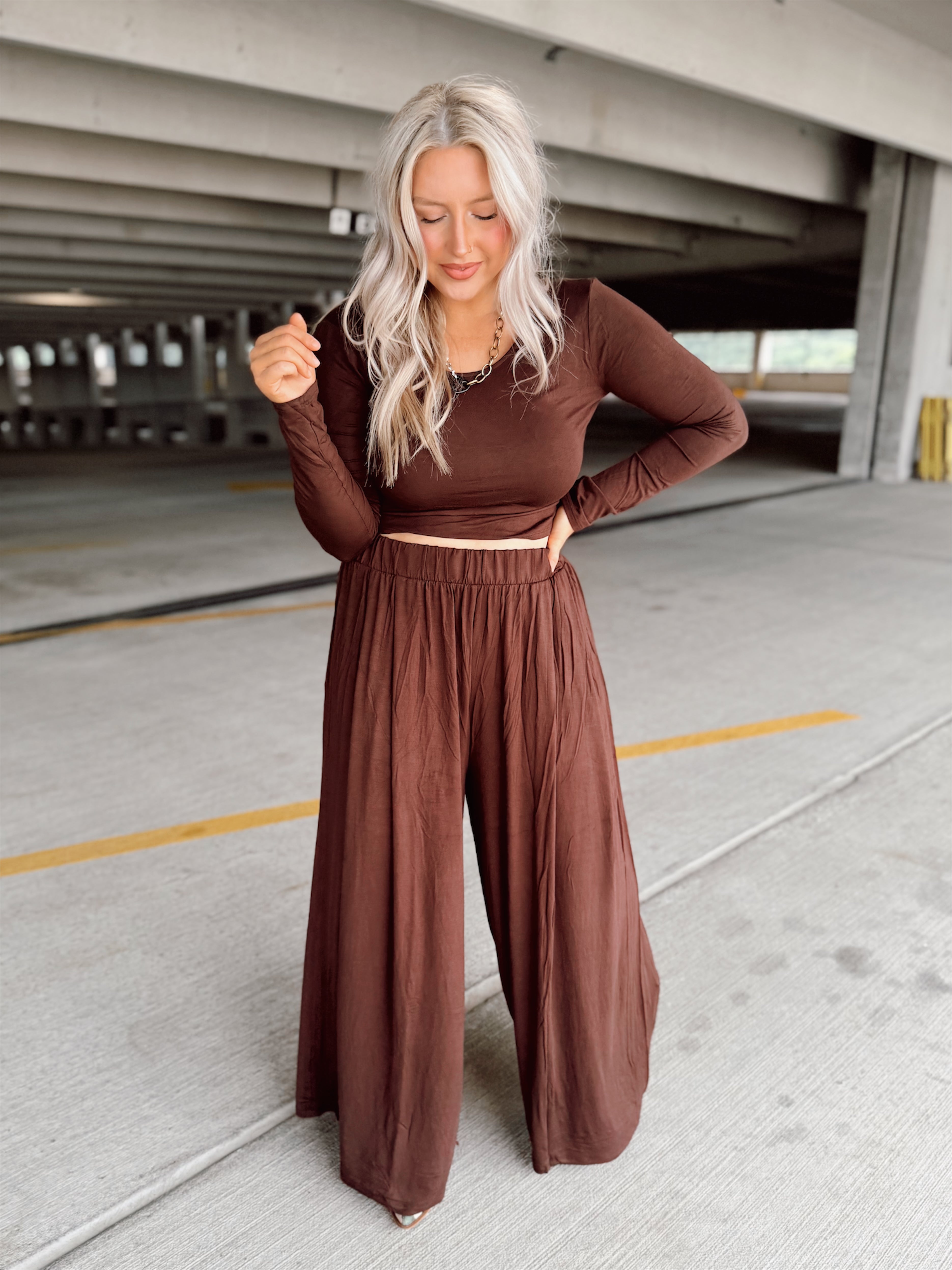 Person wearing a brown set standing in an parking garage.