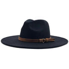 The Bethie Belted Wool Panama Hat is a black, wide-brimmed fedora featuring a brown leather band with a buckle around the crown.